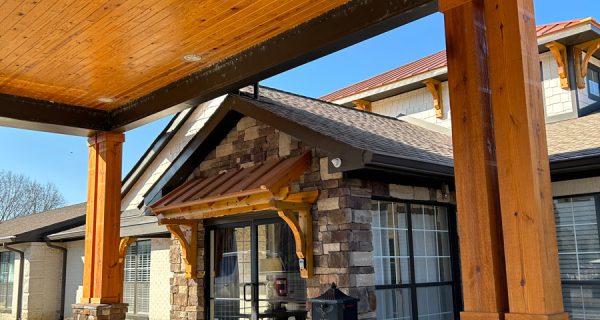 Covered entrance with timber posts, stone veneer columns, glass double doors and a paved walkway